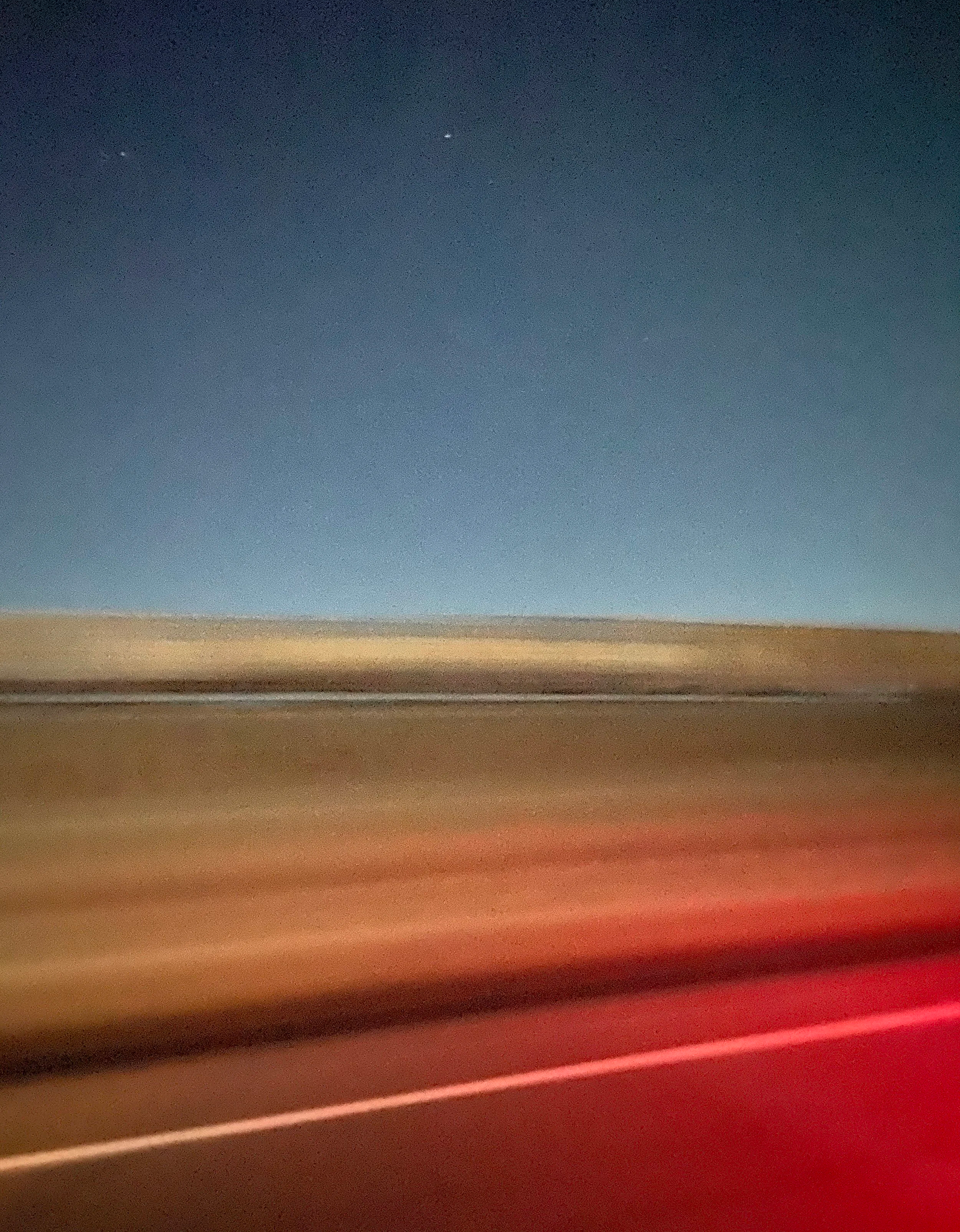 Blurred desert road landscape with red light